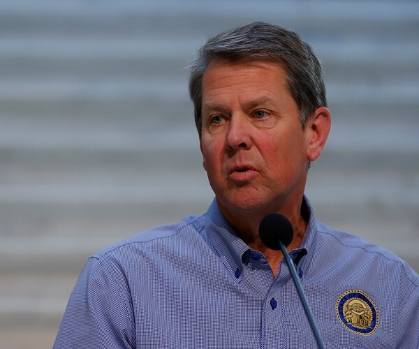 gov. brian kemp speaks at a podium in the capital of georgia