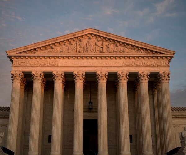 the sun is setting and reflecting off the supreme court building in washington d.c.