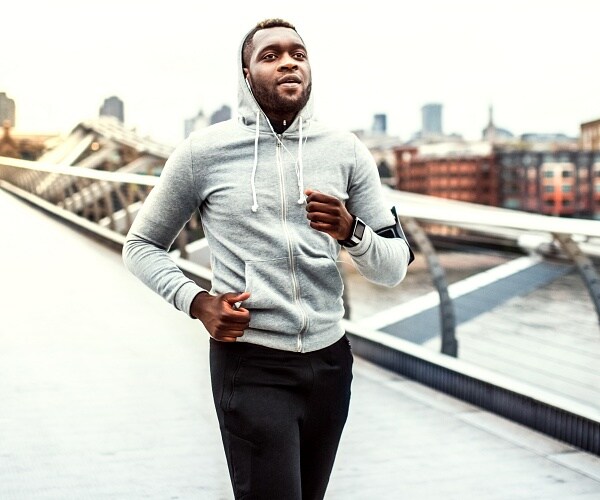 black man runs across bridge