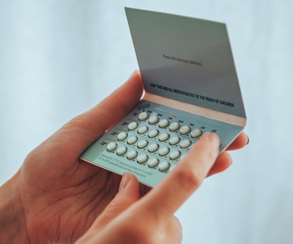 woman holds birth control pills