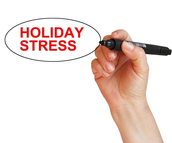 a person's hand writing 'holiday stress' and circled