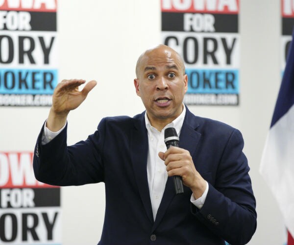sen. cory booker speaking in iowa with his campaign materials in the background