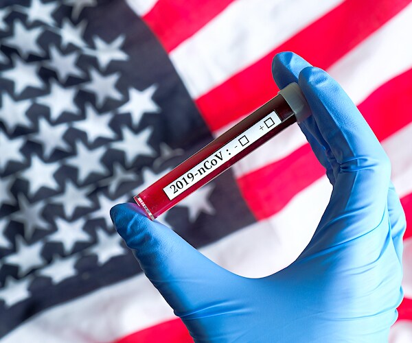 an american flag with a gloved hand holding a vile of blood marked coronavirus