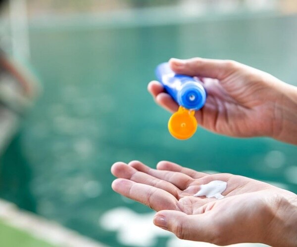 person using a sunscreen