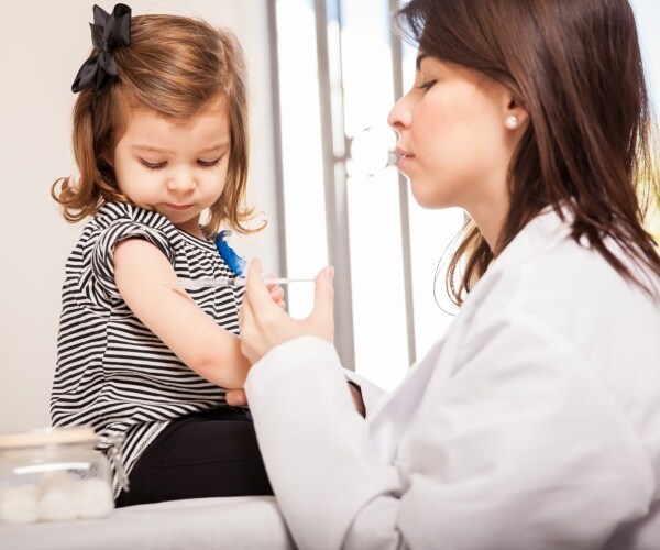 young girl getting vaccine from healthcare worker