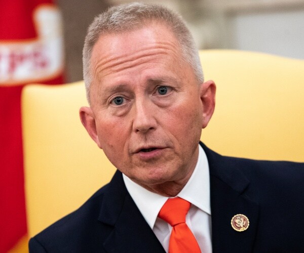 van drew in a suit and orange tie