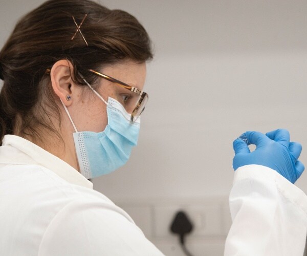 A lab technician examines a sample.