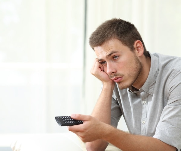 woman in pajamas watching television at night