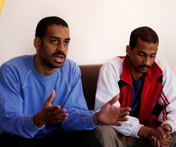 kotey in a blue shirt and elsheikh in a red and white jacket sit down on a couch and speak