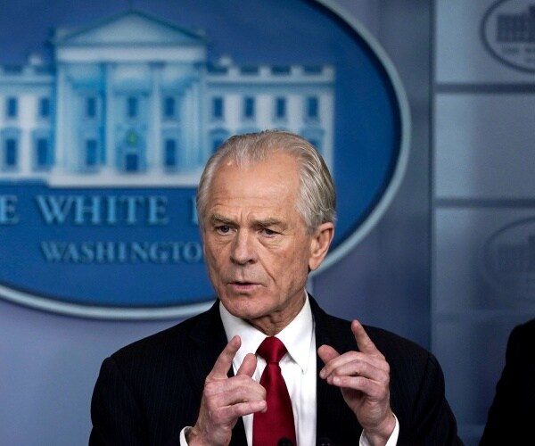 navarro in a suit and burgundy tie 