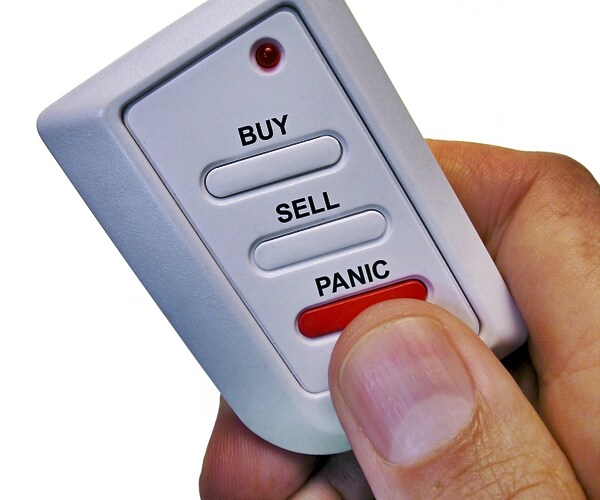 hand holding a buy sell or panic box 