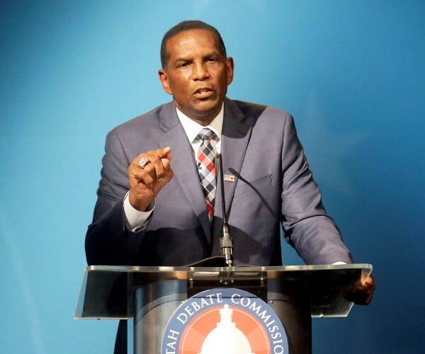 burgess owes stands behind podium