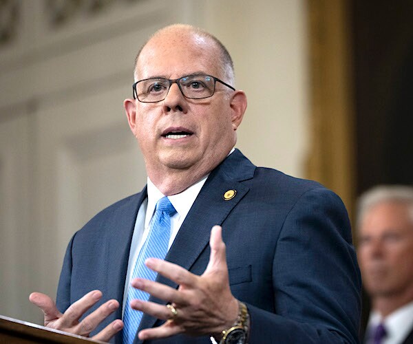 Larry Hogan behind a podium, gesturing with both hands