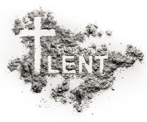 word lent and christian cross symbol drawing in ash sand or dust 
