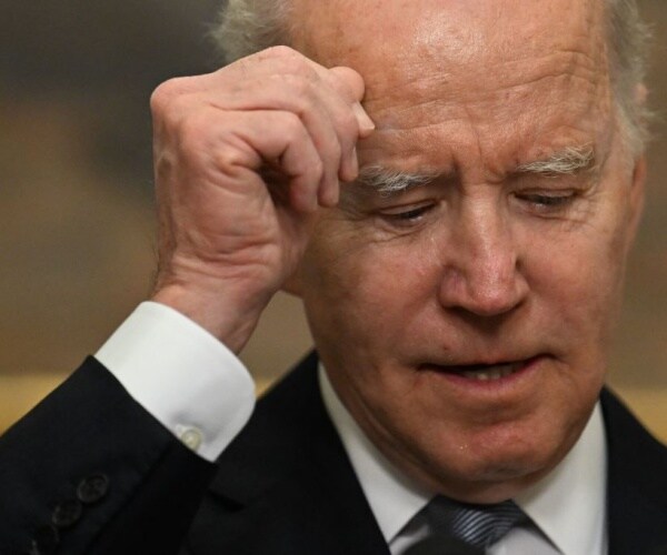 closeup of biden with hand to head