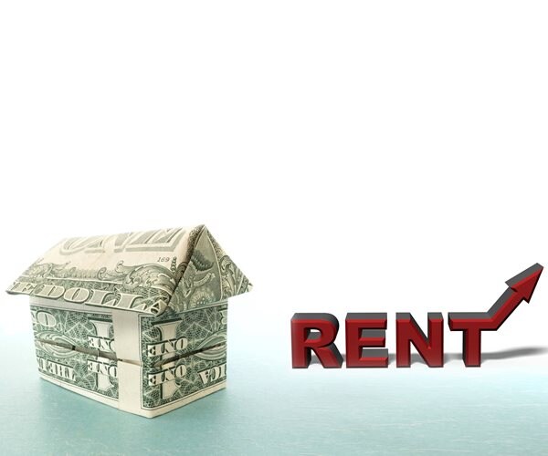 house made of bills next to word rent with an arrow pointing up