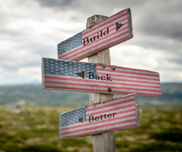build back better text on wooden signpost with the american flag