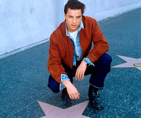 nick kamen crouches before his hollywood walk of fame star in december 1986