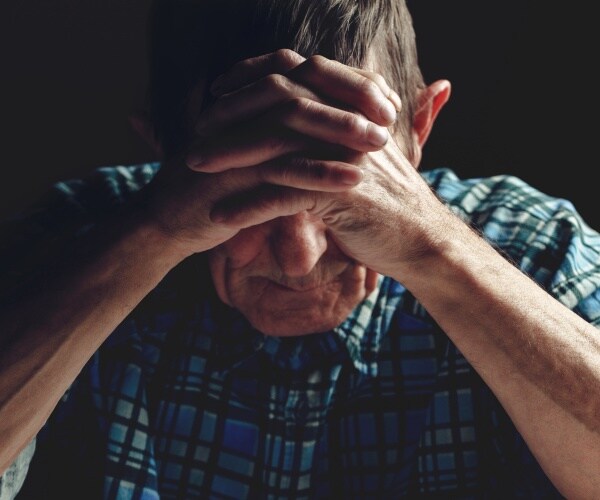 man with Alzheimer's with his head in hands