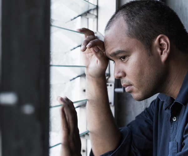 a sad man looking out the window