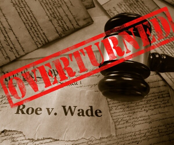 roe v wade news headline with gavel and overturned stamp on us constitution