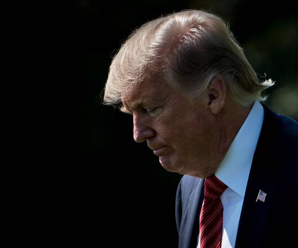 trump walks to the left looking downward