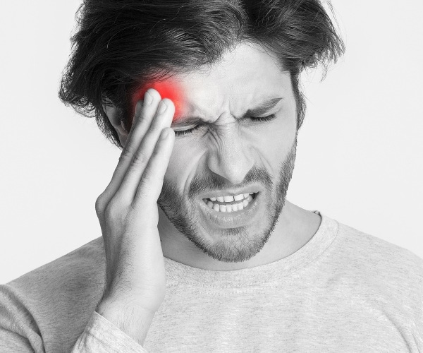 man holding head in pain