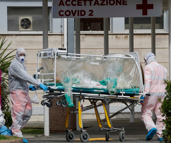 a coronavirus patient is transferred in a biocontainment unit in rome