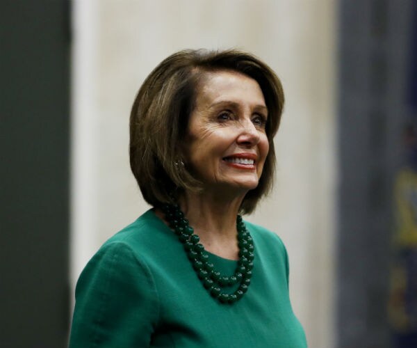 house speaker nancy pelosi wearing a green dress with a matching double strand of medium-sized pearls