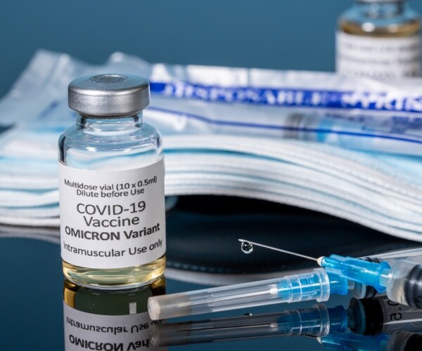 vial labeled omicron vaccine, syringe, mask