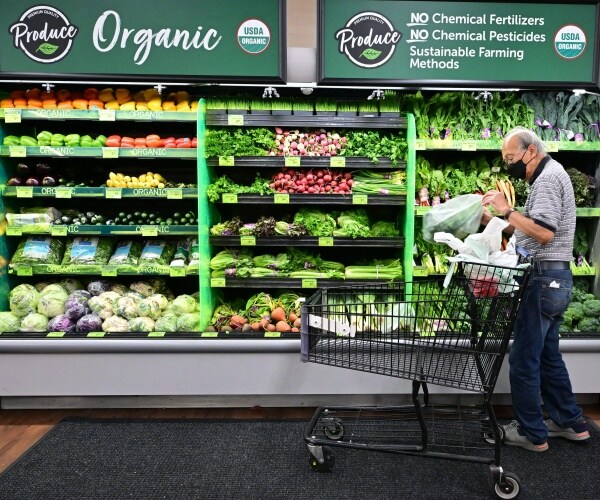 shopper looks at organic produce at a supermarket