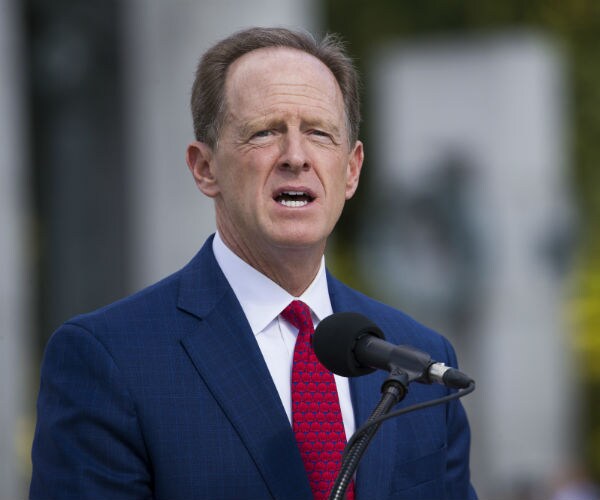sen. pat toomey is seen in a blue suit, white dress shirt and red tie