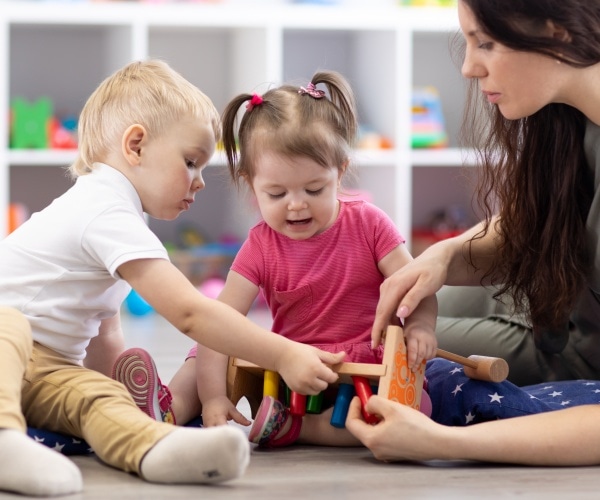 toddlers playing with teacher