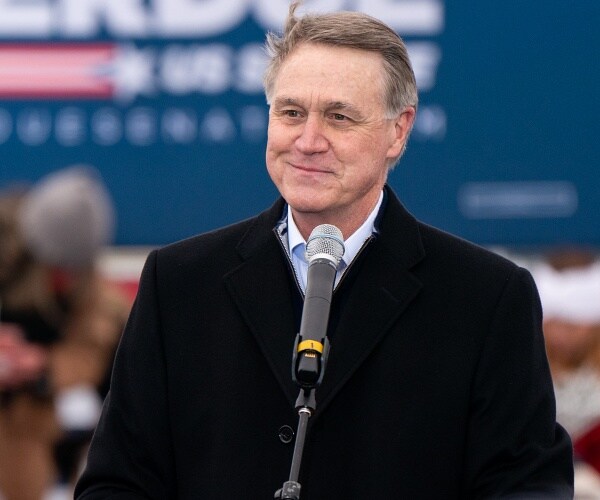 david perdue speaks into microphone at campaign rally