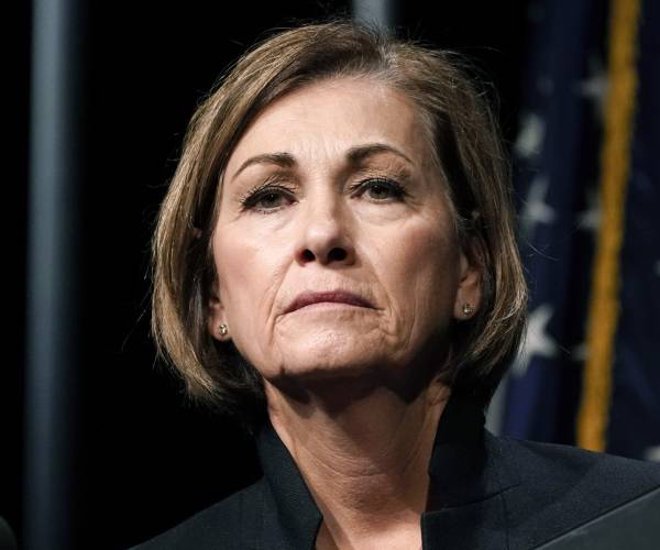 Kim Reynolds looks on