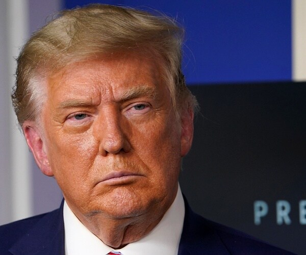 donald trump stands in briefing room