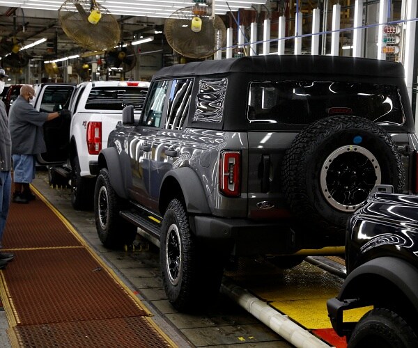 man works jeep assembly line