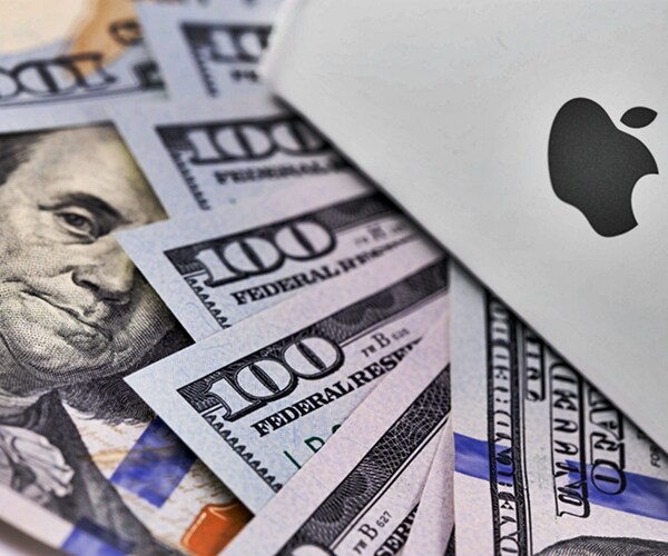 apple corporate logo symbol emblem atop one hundred dollar bills