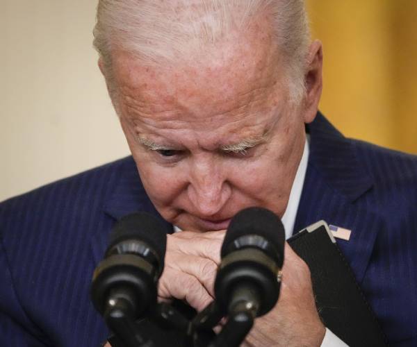 biden looks down with his hands on his chin