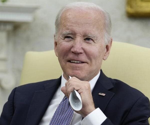 joe biden smiles as he looks on