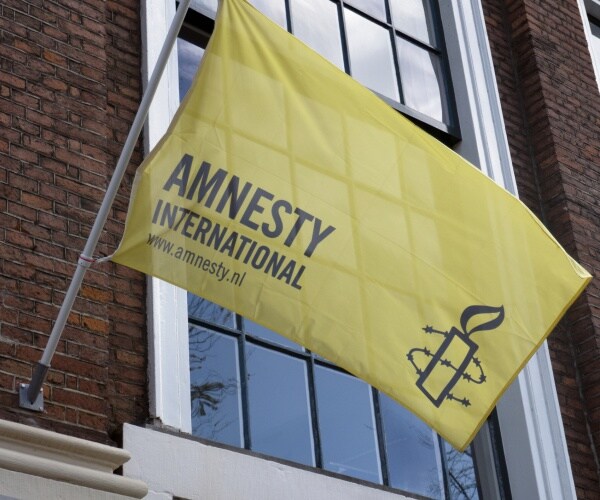 yellow amnesty international flag outside a building