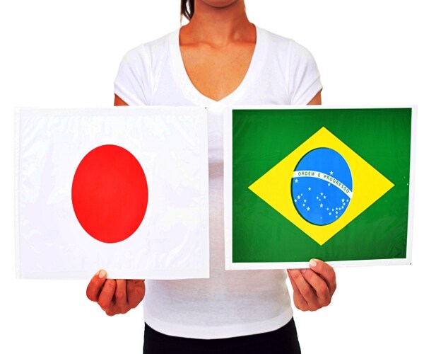 hands holding the flags. flags of japan & brazi

