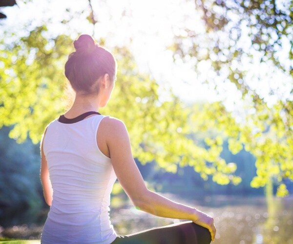 woman doing yoga outside in morning sun