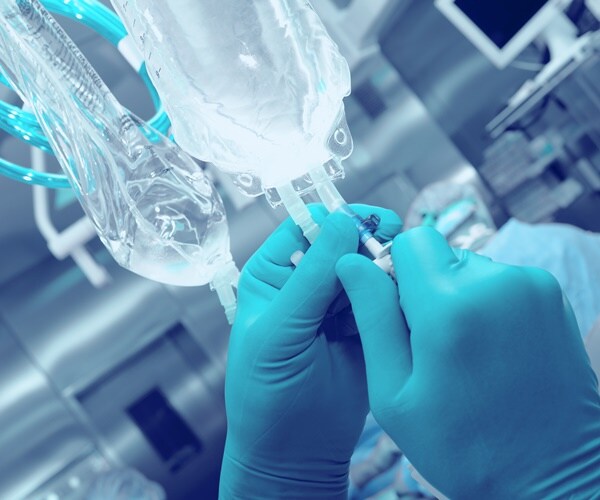 a plastic i.v. bag is readied for surgery.