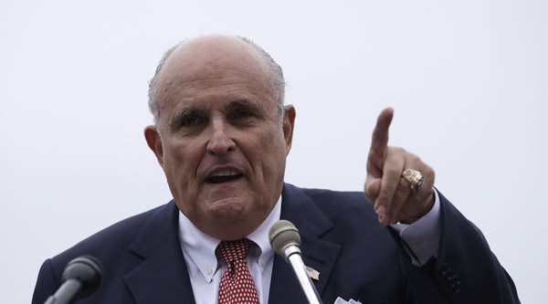 rudy giuliani speaks to a crowd and points