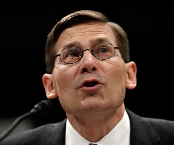 morell in a suit speaking into a mic at a hearing