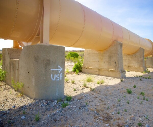 sign spray painted points immigrants toward us