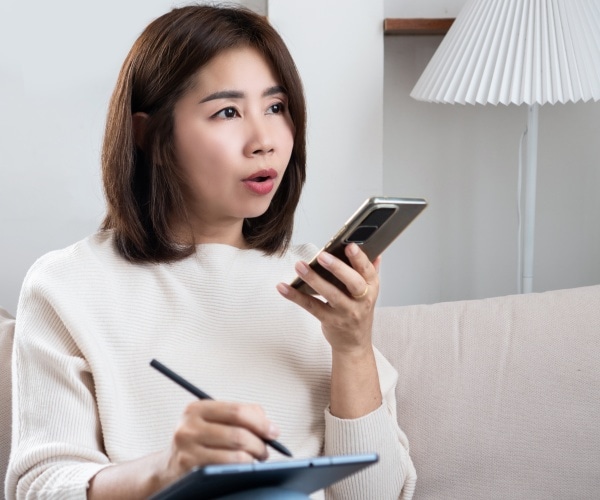 woman asking question into smartphone