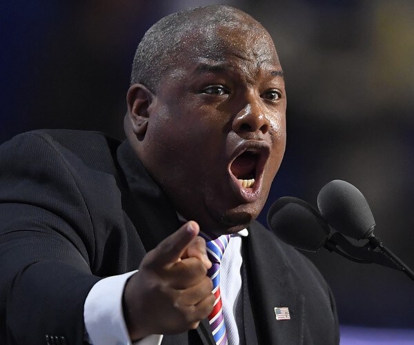 Mark Burns speaks into a microphone