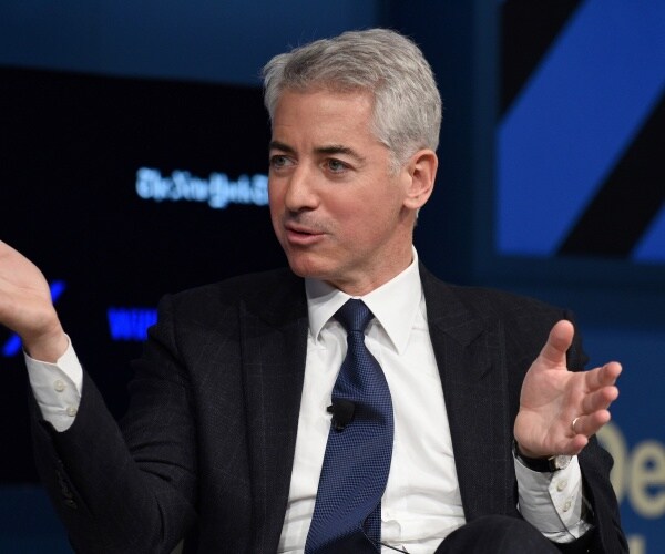 ackman in a black suit and blue tie at a new york times event